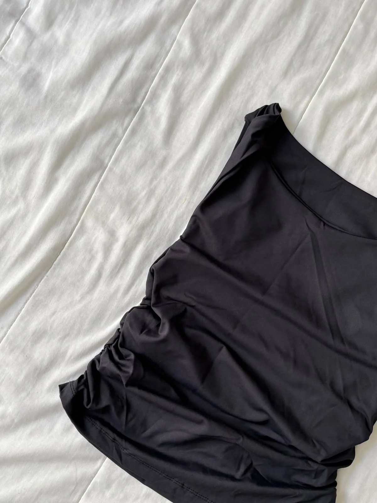Detalhe da alça trançada da blusa preta em poliamida